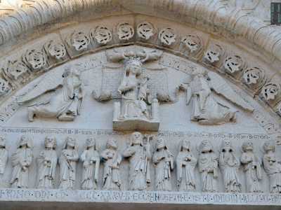 La sommit� incornicia poi una lunetta anch�essa scolpita: in alto la Vergine in trono emerge austera tra due angeli, mentre in basso Ges� con il pastorale dirige il corteo di Apostoli ai suoi lati